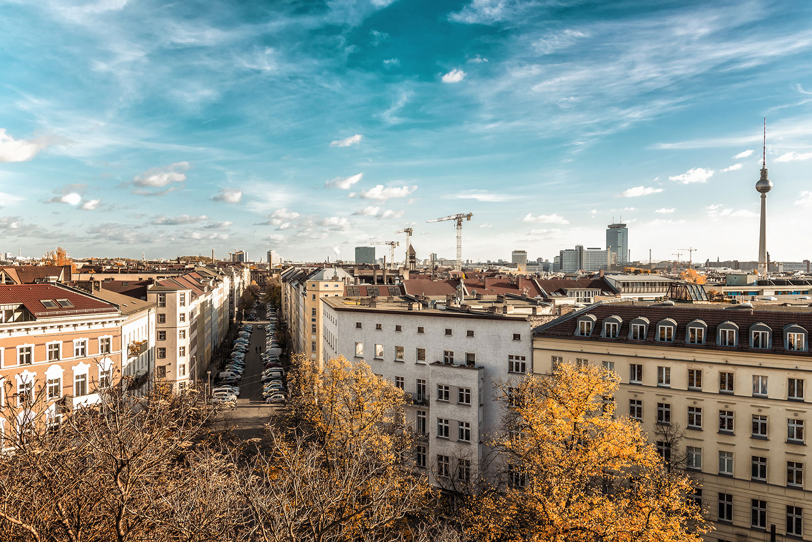 Die Skyline von Berlin mit Altbauhäusern im Vordergrund und dem Fernsehturm im Hintergrund